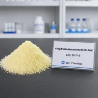 4-hydrazinobenzenesulfonic-acid-cas-98-71-5-yellow-powder-sample Pale yellow crystalline powder pile of 4-Hydrazinobenzenesulfonic Acid CAS 98-71-5 on a dark lab bench, next to a clear label card showing UET Chemical branding.
