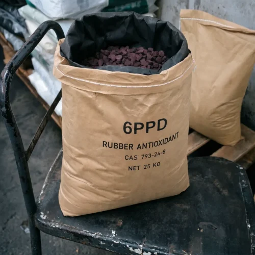 Close-up of 6PPD Rubber Antioxidant CAS 793-24-8 dark purple granules inside an opened kraft bag, featuring a black light-shielding PE inner liner to prevent oxidation and maintain product stability.