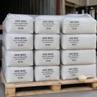 Stack of 25kg white woven bags of Alkyl Ketene Dimer (AKD Wax) CAS 144245-85-2 on wooden pallet, shrink-wrapped for stability, with sample flakes shown in scoop, labeled for industrial paper sizing use.