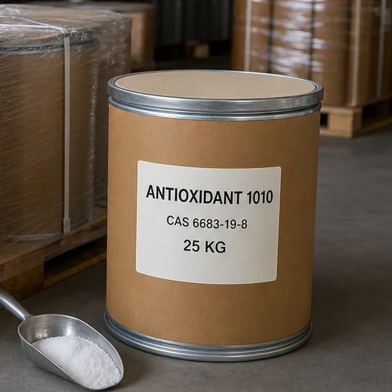 antioxidant-1010-cas-6683-19-8-white-powder-sample-with-scoop 25kg packaging drum of Antioxidant 1010 CAS 6683-19-8 next to a metal scoop filled with white powder sample, set in a warehouse with palletized stock in the background.