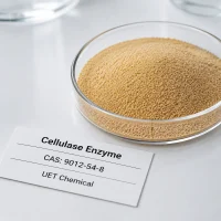 cellulase-enzyme-cas-9012-54-8-powder-sample Light brown granular powder sample of Cellulase Enzyme CAS 9012-54-8 in a clear glass dish, with product label showing UET Chemical branding.