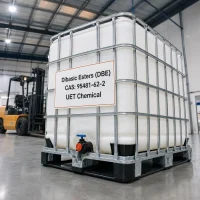 dibasic-esters-dbe-cas-95481-62-2-white-ibc-tote-tank White IBC tote tank of Dibasic Esters (DBE) CAS 95481-62-2 on a black plastic pallet in a warehouse, label showing UET Chemical branding, with a forklift visible in the background.