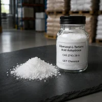 dibenzoyl-l-tartaric-acid-anhydrous-white-powder-sample Close-up of white crystalline powder of Dibenzoyl-L-Tartaric Acid Anhydrous (CAS 2743-38-6) in a glass sample bottle and on a black slate surface, UET Chemical