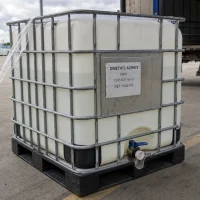 dimethyl-adipate-dma-cas-627-93-0-1000kg-ibc-tote-bulk-liquid 1000kg IBC tote of Dimethyl Adipate (DMA) CAS 627-93-0 in a galvanized metal cage with a blue bottom discharge valve, designed for convenient bulk liquid solvent transport and storage.