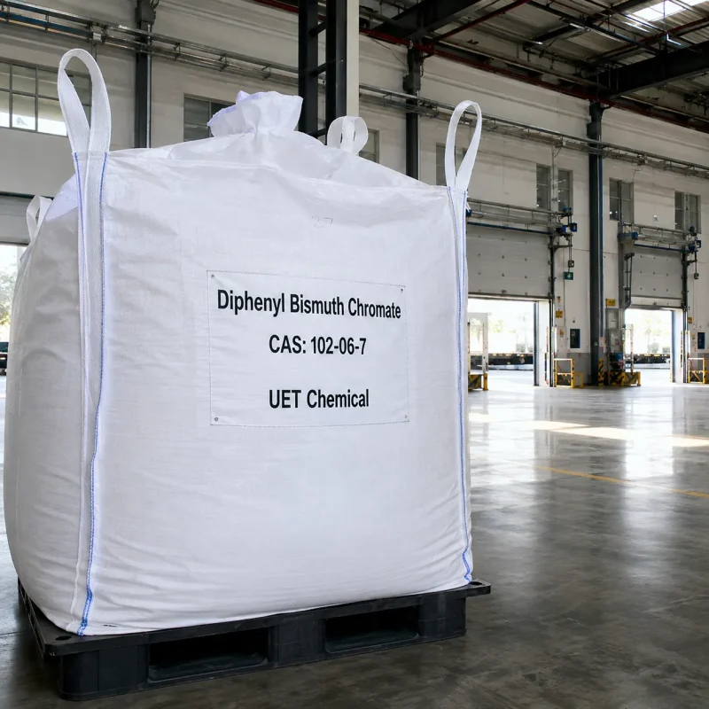 diphenyl-bismuth-chromate-cas-102-06-7-white-ton-bag-fibc Large white FIBC ton bag of Diphenyl Bismuth Chromate CAS 102-06-7 with label showing UET Chemical branding, placed on a black plastic pallet inside a spacious industrial warehouse.
