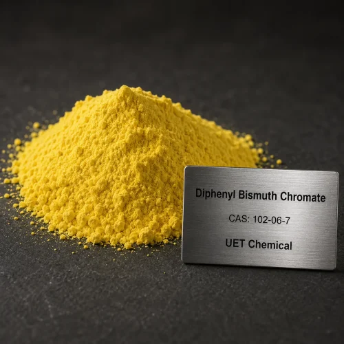 diphenyl-bismuth-chromate-cas-102-06-7-yellow-powder-sample Bright yellow powder sample of Diphenyl Bismuth Chromate CAS 102-06-7 piled on a dark surface, next to a metal nameplate showing UET Chemical branding and product details.