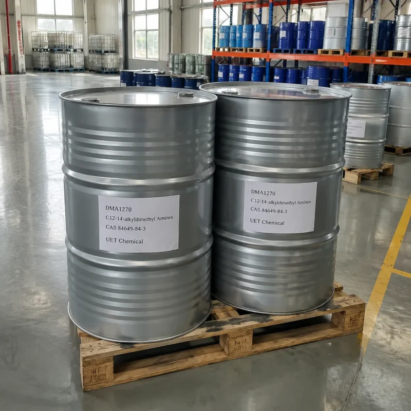 dma1270-c12-14-alkyldimethyl-amines-silver-metal-drum-warehouse Two silver metal drums (Net Weight: 200kg) of C12-14 Alkyldimethyl Amines (DMA1270, CAS 84649-84-3) on wooden pallet in warehouse aisle, labeled UET Chemical, bulk storage for chemical intermediate and fabric softener production