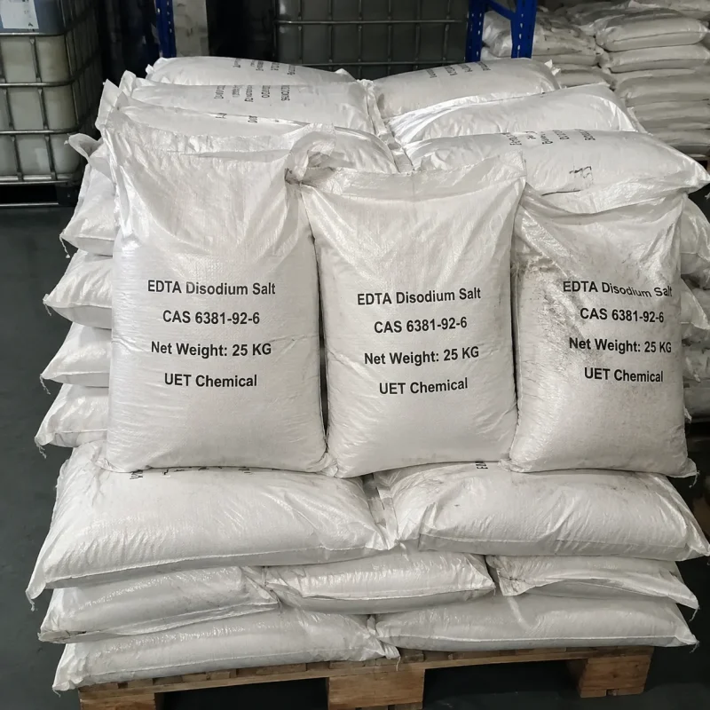 edta-disodium-salt-cas-6381-92-6-25kg-bulk-bags-warehouse Stacks of 25kg white woven bags containing EDTA Disodium Salt CAS 6381-92-6 on a wooden pallet in a warehouse, supplied by UET Chemical.