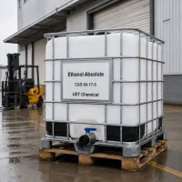 ethanol-absolute-cas-64-17-5-ibc-tote-tank-factory-logistics-uetchmical White IBC tote tank of Ethanol Absolute CAS 64-17-5 ready for shipment near a factory loading dock with a forklift, showcasing bulk logistics capabilities of UET Chemical.