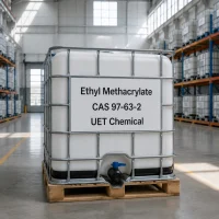 White IBC tote of Ethyl Methacrylate EMA CAS 97-63-2 with metal cage and discharge valve, labeled with UET Chemical branding, positioned on a wooden pallet inside a warehouse.