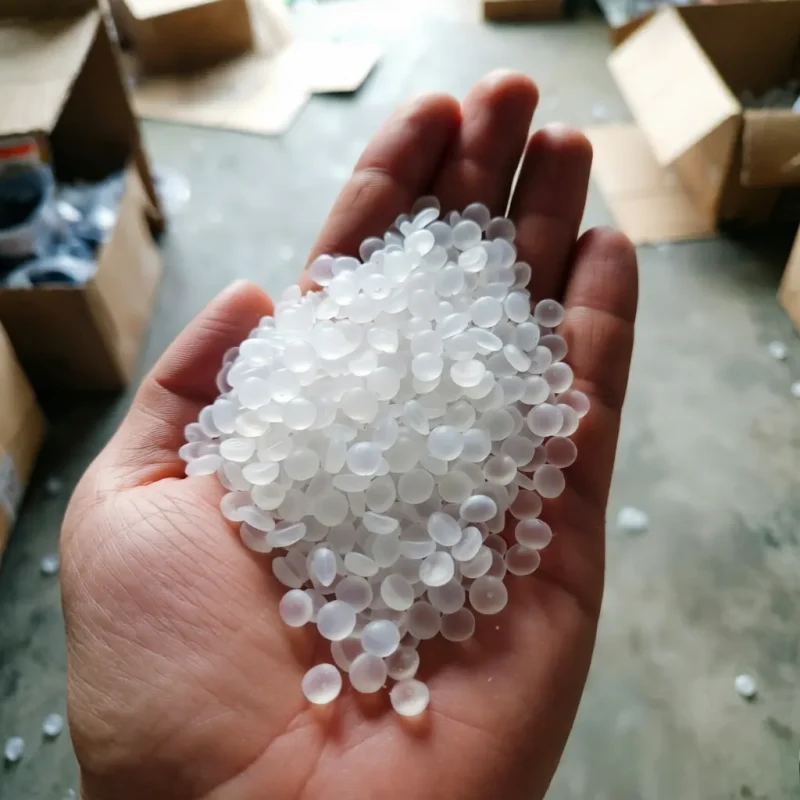ethylene-vinyl-acetate-eva-pellets-close-up-hand Close-up image of translucent white ethylene-vinyl acetate (EVA) copolymer pellets held in a person's hand, demonstrating the uniform particle size and smooth surface ideal for hot melt adhesives and foam products.