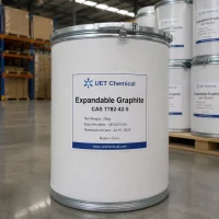 expandable-graphite-cas-7782-42-5-25kg-white-fiber-drum-uet-chemical A 25kg white fiber drum of Expandable Graphite CAS 7782-42-5 with metal clasp lid, labeled with batch number UE25071001 and manufacture date Jul 10, 2025, by UET Chemical in warehouse.