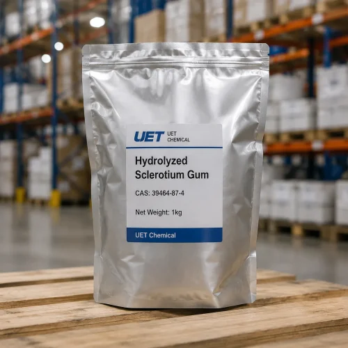 hydrolyzed-sclerotium-gum-cas-39464-87-4-1kg-silver-foil-bag-sample A 1kg silver foil resealable bag of Hydrolyzed Sclerotium Gum CAS 39464-87-4 standing on a wooden pallet, labeled with UET Chemical branding, suitable for samples or small quantity orders.