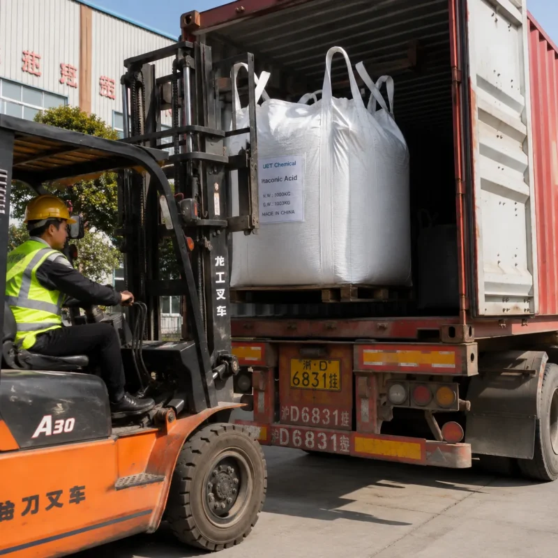 itaconic-acid-cas-97-65-4-1000kg-jumbo-bag-container-loading Forklift loading a 1000 kg jumbo bag of Itaconic Acid (CAS 97-65-4) into a container for export shipment