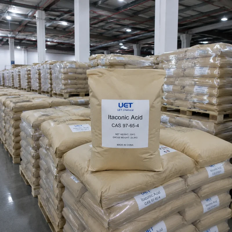 itaconic-acid-cas-97-65-4-25kg-kraft-bags-warehouse-stock 25 kg kraft bags of Itaconic Acid (CAS 97-65-4) stacked on pallets in UET Chemical warehouse with large ready stock