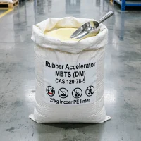 mbt-s-dm-rubber-accelerator-25kg-pe-lined-bag One of our 25kg rubber accelerator MBTS (DM) bags sitting open in the warehouse. A stainless steel scoop is resting inside the pale yellow granules. The label clearly marks the product, CAS 120-78-5, and the inner PE liner, which keeps the rubber chemical safe from moisture before use.