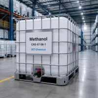 methanol-methyl-alcohol-ibc-tote-tank-flammable-liquid White IBC tote tank with metal cage frame containing Methanol (CAS 67-56-1), labeled UET Chemical, displaying flammable liquid hazard symbol, arranged in warehouse for large-volume industrial distribution