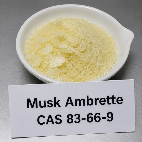 musk-ambrette-pale-yellow-crystals-fragrance-cas-83-66-9 Pale yellow musk ambrette crystals CAS 83-66-9, synthetic musk fragrance fixative, in white ceramic dish with label card