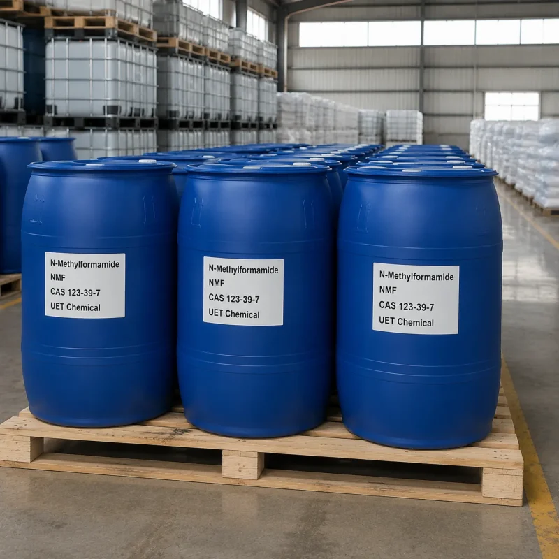 n-methylformamide-nmf-blue-drum-pallet-warehouse Multiple blue plastic drums of N-Methylformamide (NMF, CAS 123-39-7) arranged on wooden pallets in industrial warehouse, labeled UET Chemical, bulk packaging for industrial solvent applications