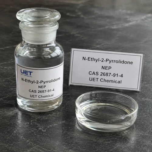 nep-n-ethyl-2-pyrrolidone-clear-liquid-sample-bottle Clear glass reagent bottle filled with colorless liquid N-Ethyl-2-Pyrrolidone (NEP, CAS 2687-91-4) on dark stone surface with glass petri dish beside, labeled UET Chemical, sample for solvent and chemical intermediate verification