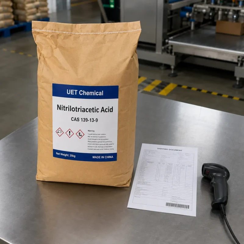 nitrilotriacetic-acid-nta-cas-139-13-9-kraft-paper-bag-shipping-uetchmical 25kg Kraft paper bag of Nitrilotriacetic Acid (NTA) CAS 139-13-9 on a metal table with shipping documents and scanner, ready for dispatch by UET Chemical.