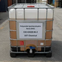 polyamide-epichlorohydrin-resin-pae-cas-63428-84-2-ibc-tote-tank An IBC tote tank containing Polyamide Epichlorohydrin Resin (PAE) CAS 63428-84-2 with amber liquid visible inside, featuring a metal cage and discharge valve, located in an outdoor storage yard.