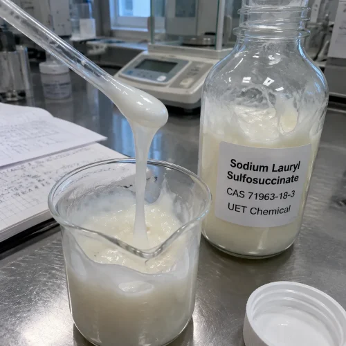 White creamy Sodium Lauryl Sulfosuccinate (CAS 71963-18-3) mild surfactant paste poured into a beaker beside a UET Chemical bottle