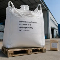 sodium-stannate-trihydrate-cas-12209-98-2-1000kg-ton-bag A 1000kg white ton bag of Sodium Stannate Trihydrate CAS 12209-98-2 on wooden pallet, with a 25kg paper bag beside it for scale, outside a factory building.