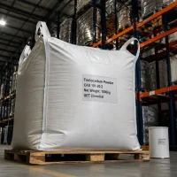 triclocarban-powder-cas-101-20-2-1000kg-ton-bag-bulk A large 1000kg white ton bag of Triclocarban Powder CAS 101-20-2 labeled UET Chemical on a wooden pallet, with a small sample drum beside it for size reference in a warehouse.