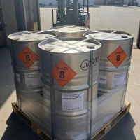 Pallet of metal drums containing Trifluoromethanesulfonic Acid CAS 1493-13-6, clearly labeled with Class 8 Corrosive hazard diamonds and UN markings, ready for shipment with a forklift in the background.