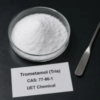 White crystalline powder sample of Trometamol (Tris) CAS 77-86-1 in a glass petri dish on a black background, with a metal spatula and product label showing UET Chemical branding.