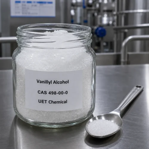 Glass jar containing white crystalline Vanillyl Alcohol CAS 498-00-0 with a metal spoon, displaying high purity for laboratory testing and flavor applications by UET Chemical.